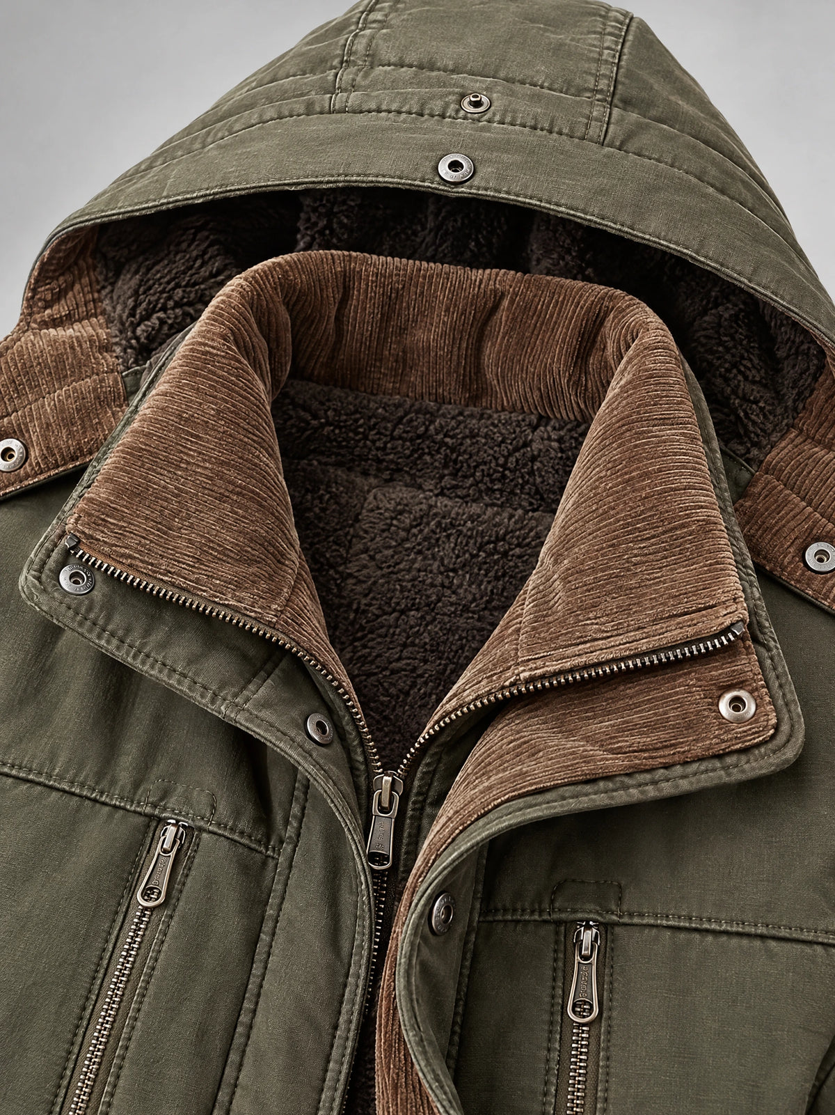 Green heavy winter jacket detail showing the fleece-lined hood, ribbed collar, snap placket, and zippered chest pockets.