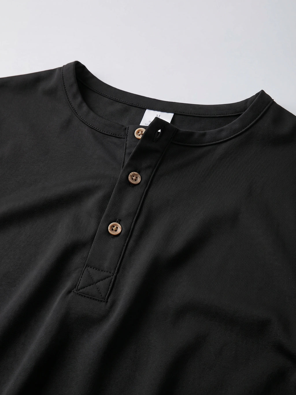 Close-up of the Black men's Henley T-shirt showing the ribbed collar and three-button placket.