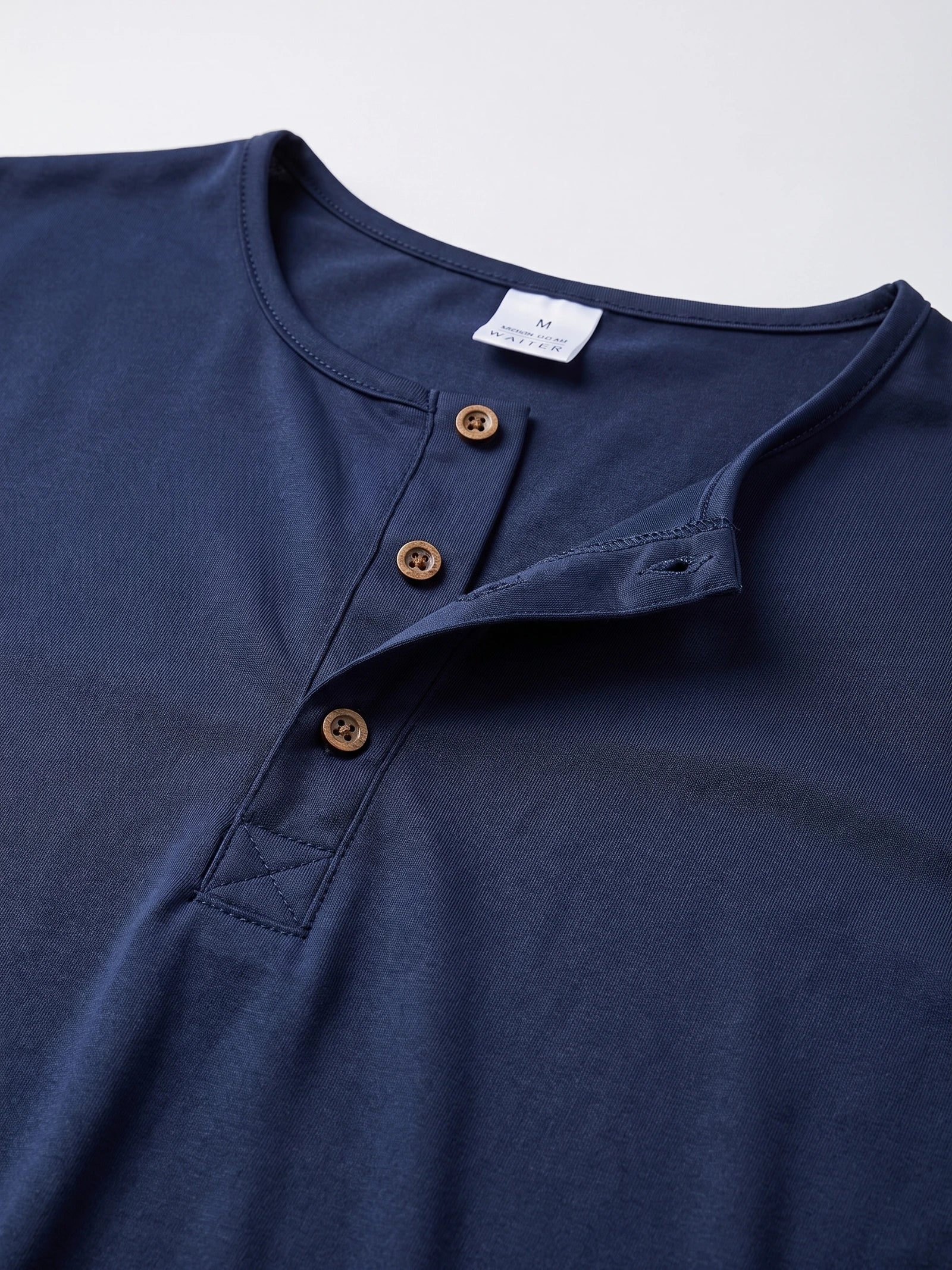 Close-up of the Navy Henley T-shirt neckline with a three-button placket and stitched collar trim.