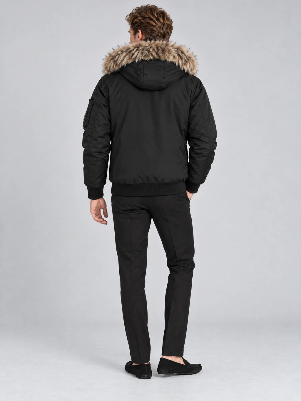 Rear view of a model wearing a Black Hooded Fur Collar Jacket with a fur-trimmed hood and ribbed hem.