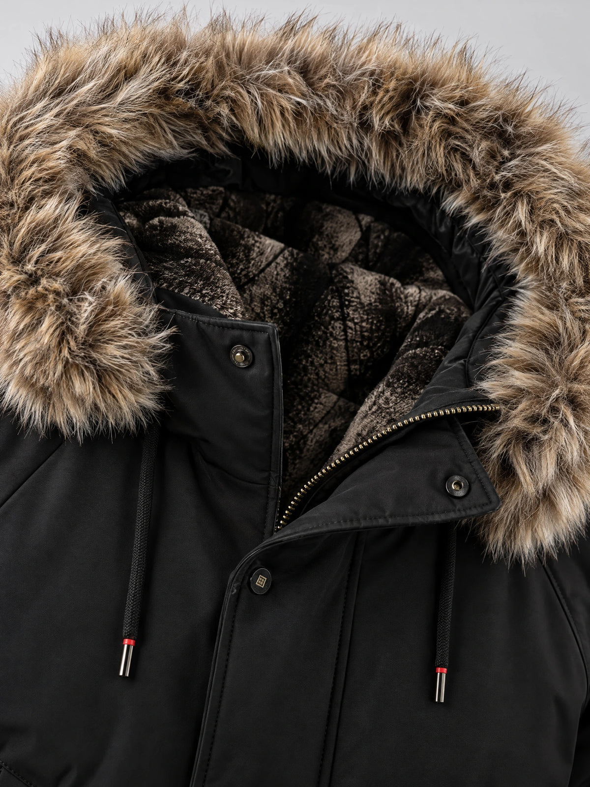 Close-up of the Black Hooded Fur Collar Jacket showing the fur-trimmed hood, fleece lining, zipper, and snap-button storm flap.