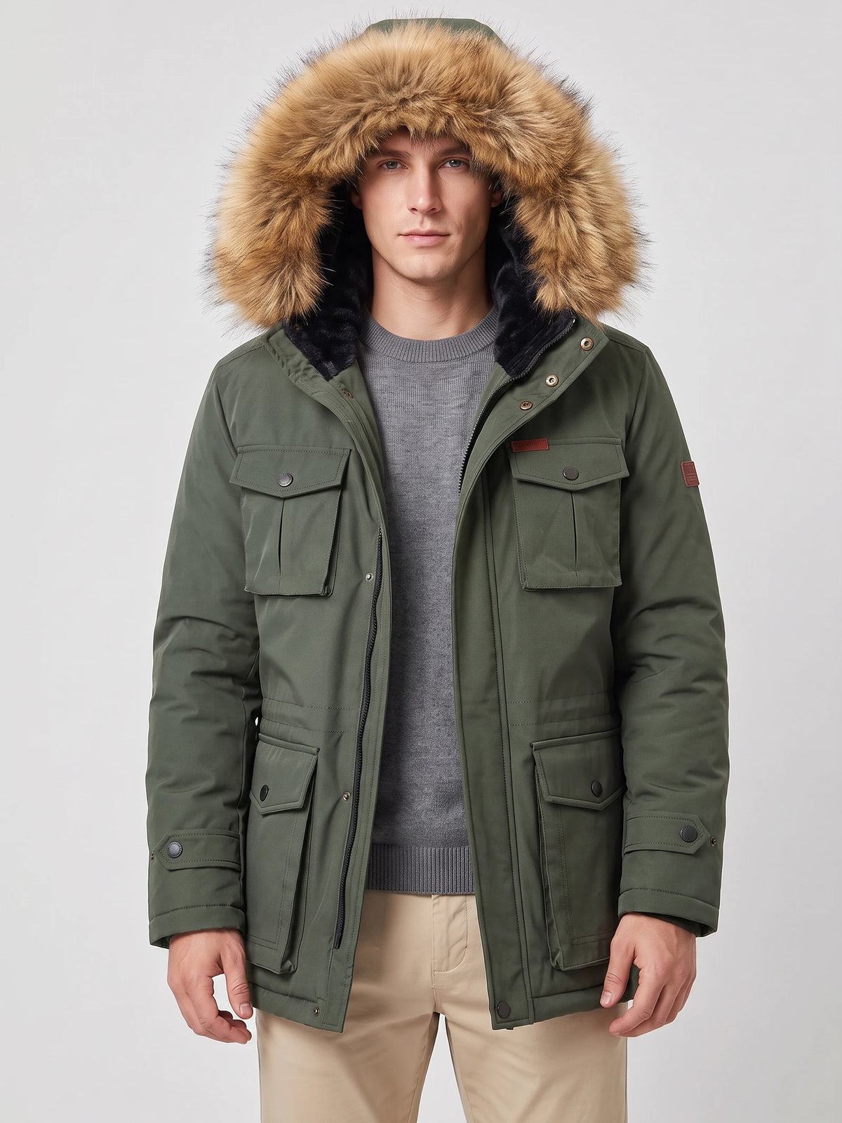 Front studio view of a model wearing a Green men's parka with a fur-trimmed hood and flap pockets.