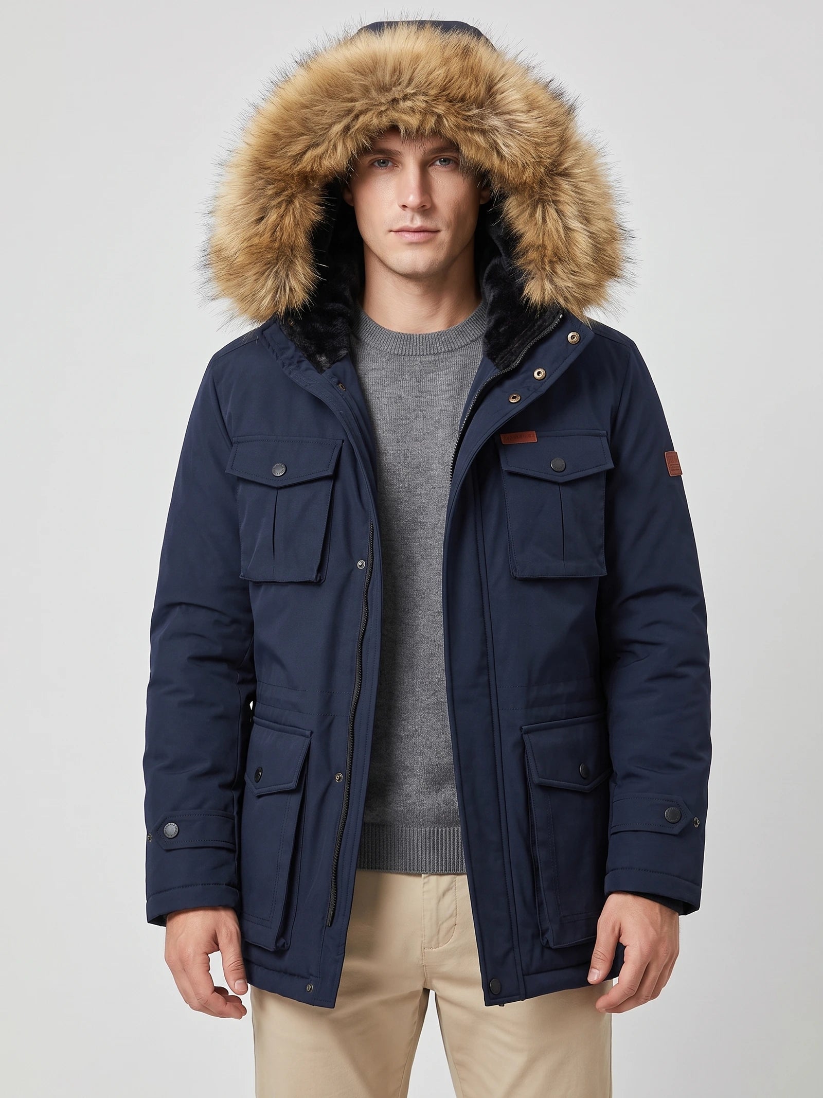 Front studio view of a model wearing a Navy men's parka with a fur-trimmed hood and flap pockets.
