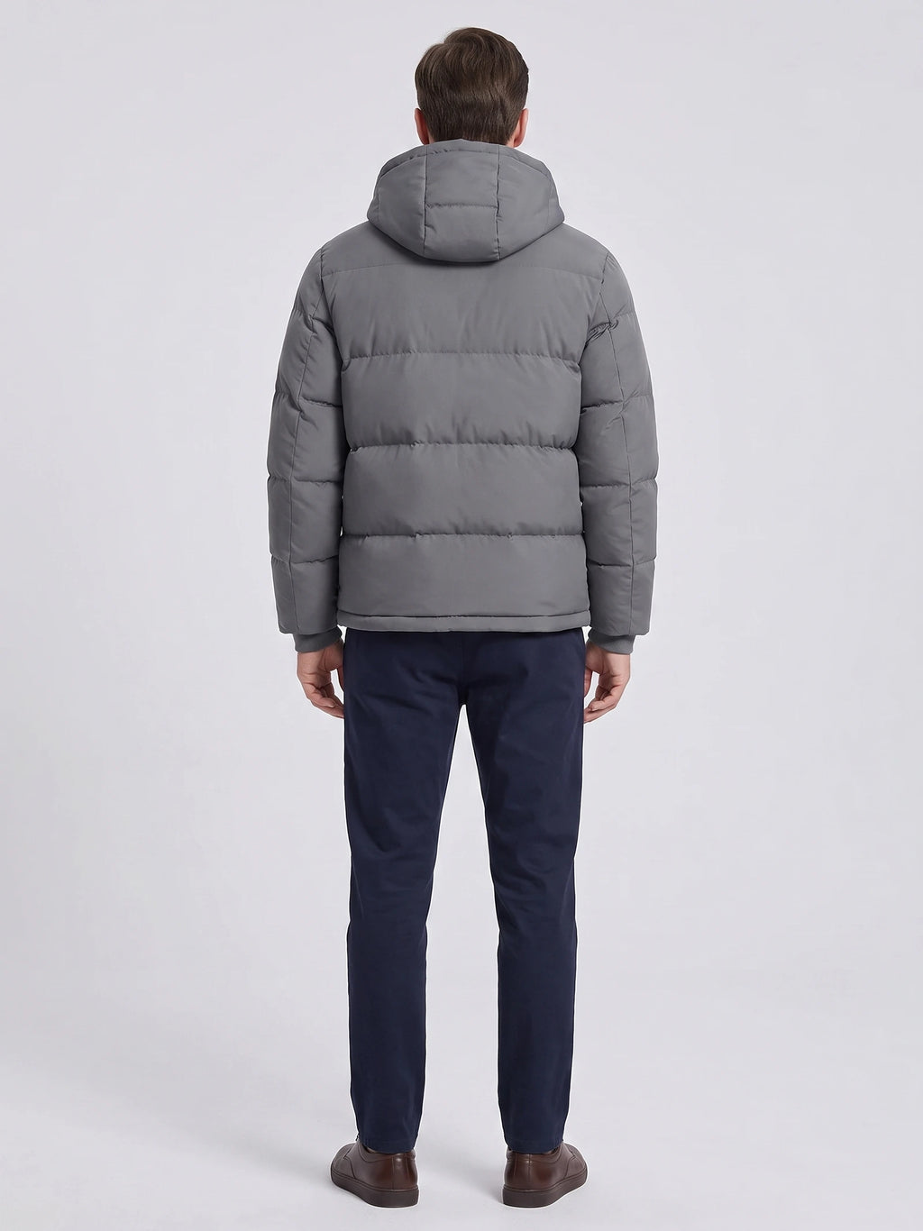 Rear studio view of a model wearing a Gray Hooded Puffer Jacket with horizontal quilted panels and a padded hood.