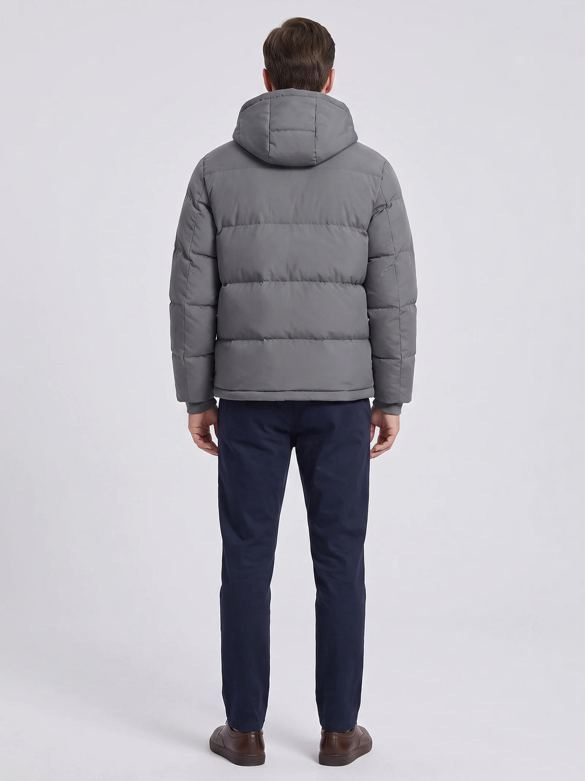 Rear studio view of a model wearing a Gray Hooded Puffer Jacket with horizontal quilted panels and a padded hood.