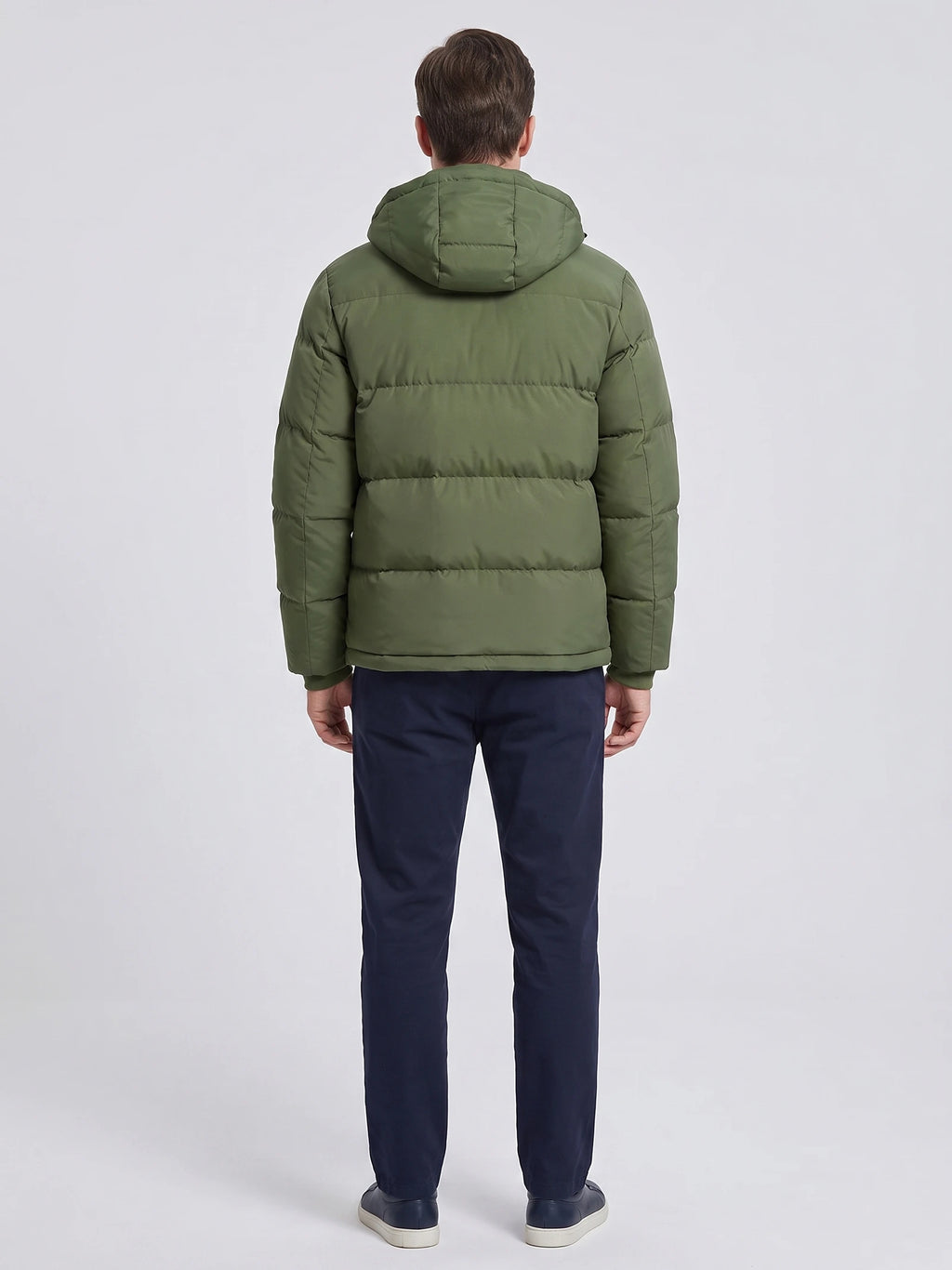 Rear studio view of a model wearing a Green Hooded Puffer Jacket with horizontal quilted panels and a padded hood.
