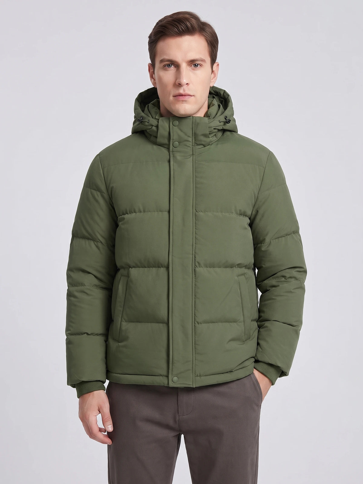 Front studio view of a model wearing a Green hooded puffer jacket with a snap-front placket and angled pockets.