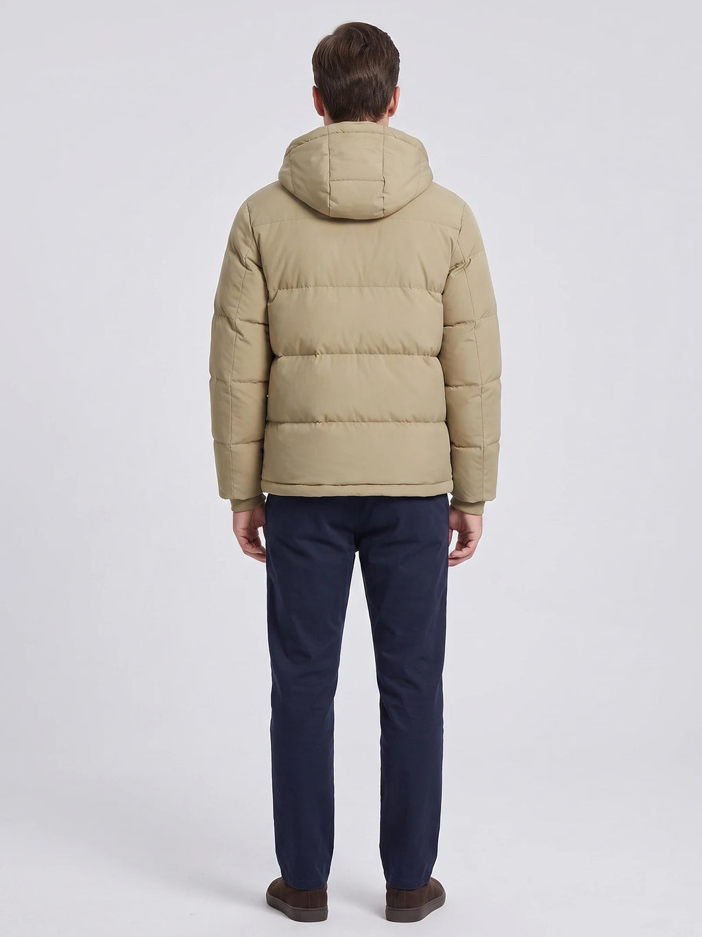 Rear studio view of a model wearing a Khaki hooded puffer jacket with horizontal quilted panels and an attached hood.