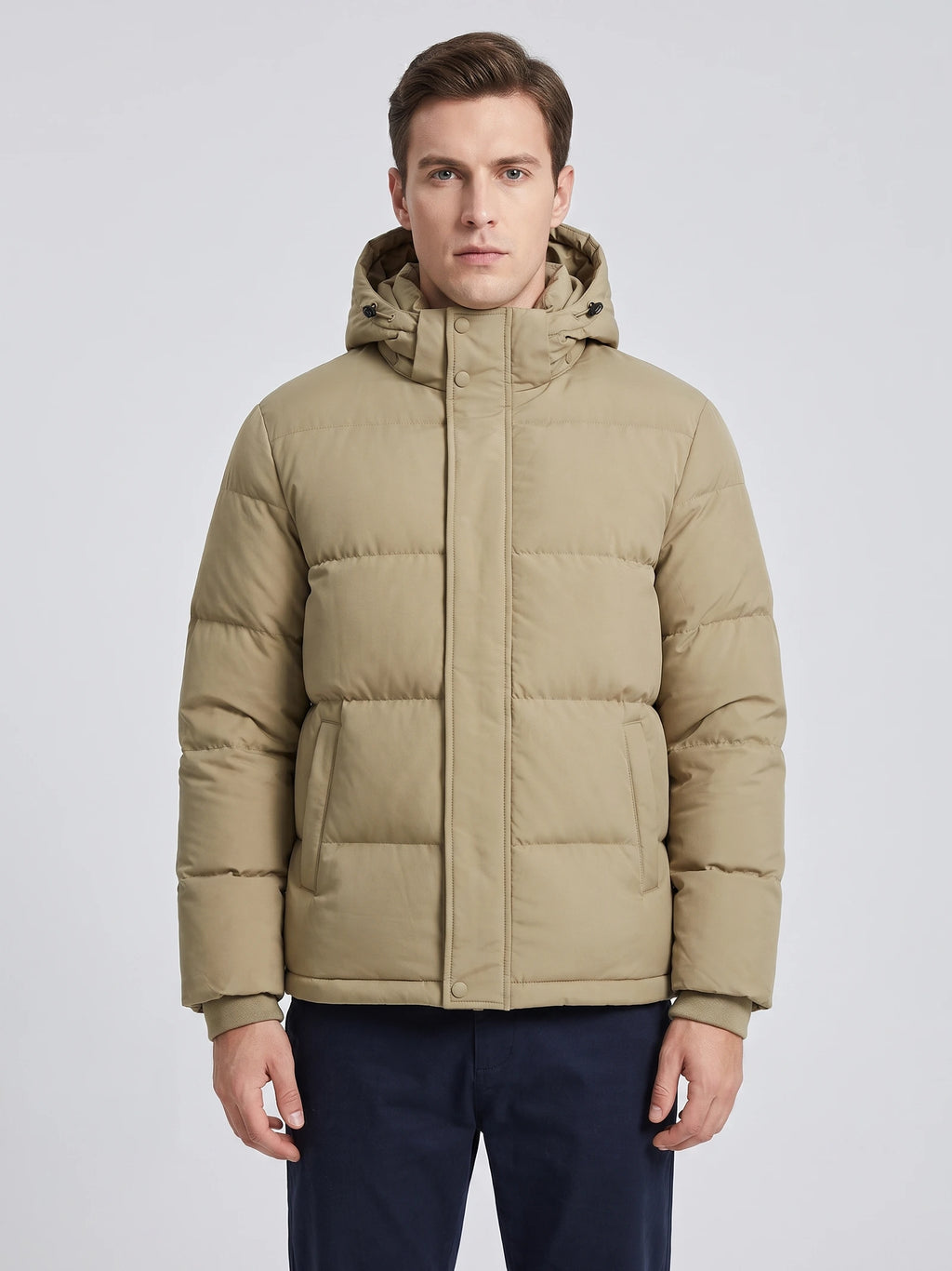 Front studio view of a model wearing a Khaki Hooded Puffer Jacket with quilted panels, snap placket, and front pockets.