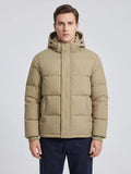 Front studio view of a model wearing a Khaki Hooded Puffer Jacket with quilted panels, snap placket, and front pockets.