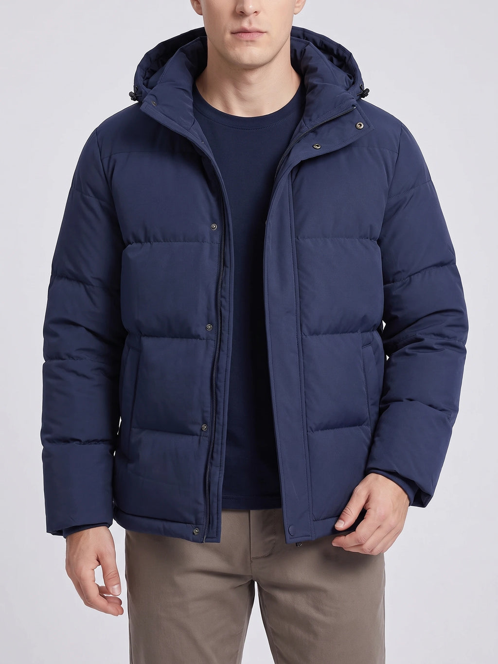 Front studio view of a model wearing a Navy hooded puffer jacket with quilted panels, zip closure, and snap-button storm flap.