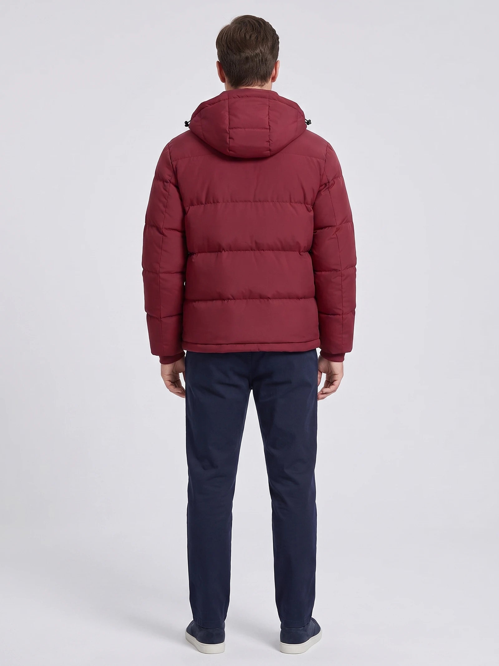 Rear view of a model wearing a Wine hooded puffer jacket with horizontal quilted panels.
