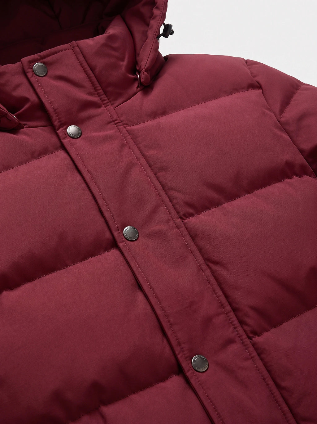 Close-up of the Wine Hooded Puffer Jacket showing quilted stitching, a snap-button storm flap, and adjustable hood toggle.