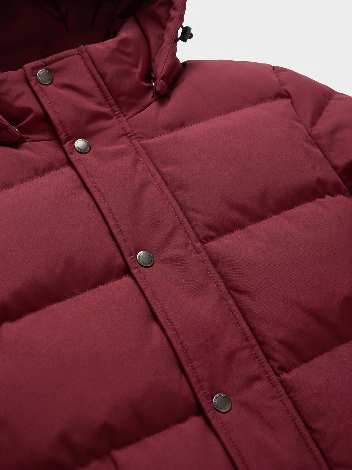 Close-up of the Wine Hooded Puffer Jacket showing quilted stitching, a snap-button storm flap, and adjustable hood toggle.
