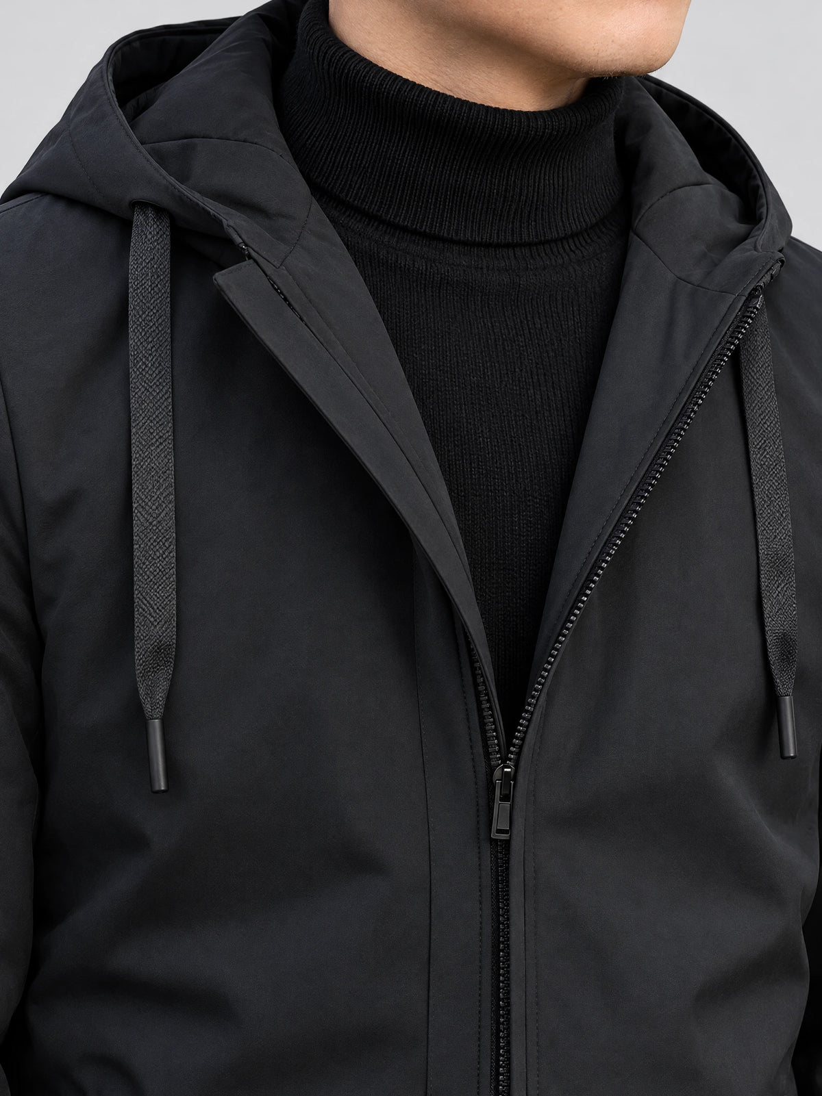 Close-up of the Black Men’s Hooded Trench Coat showing the hood, textured drawstrings, and front zipper.