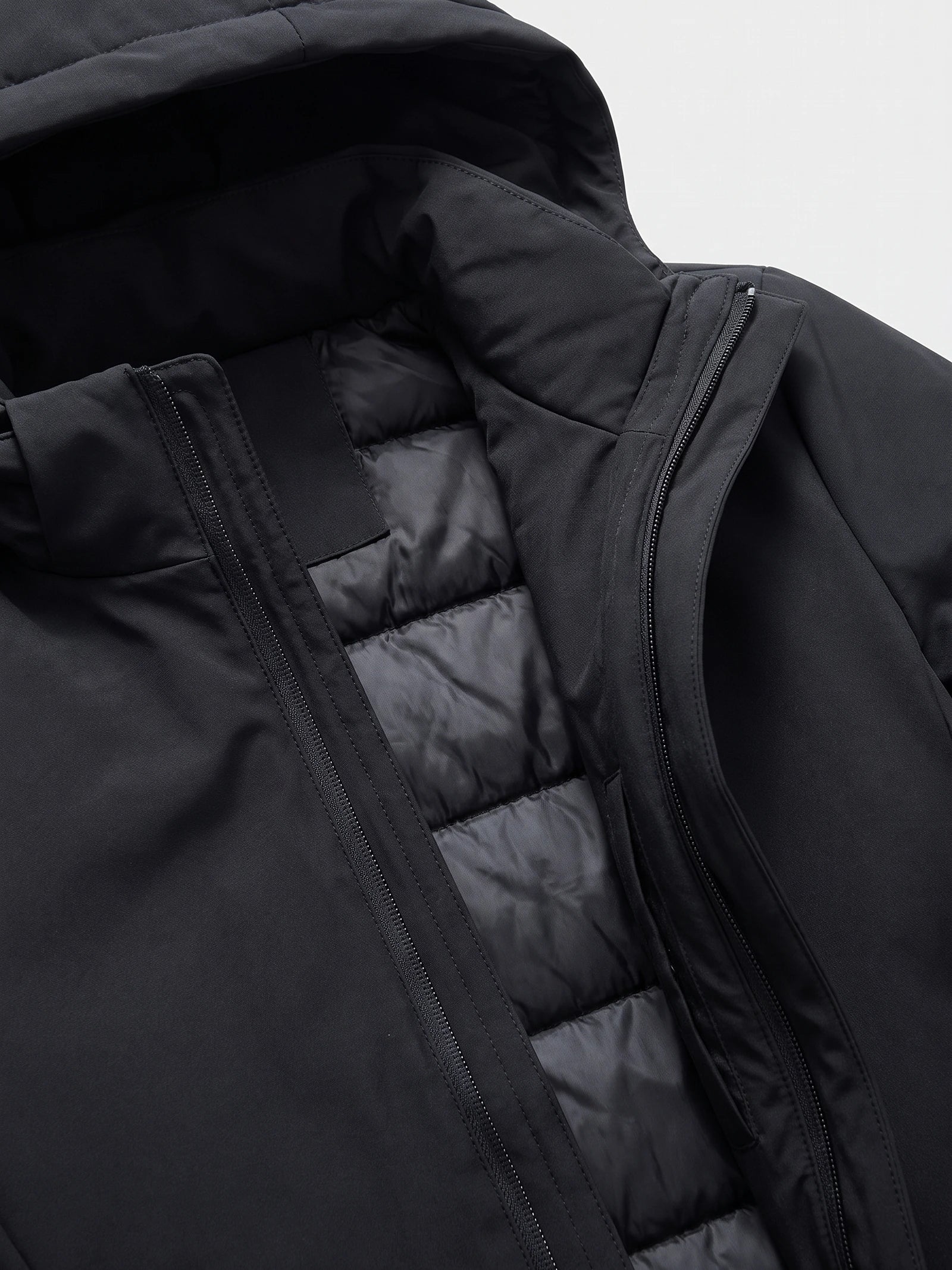 Close-up of the Black hooded trench coat showing the front zipper, storm flap, and quilted padded lining.