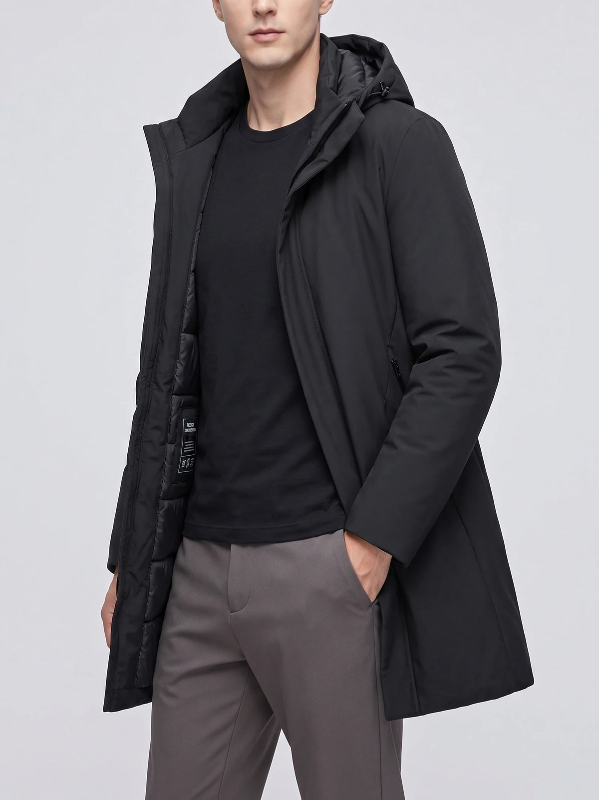 Front studio view of a model wearing a Black hooded trench coat with an open front and padded lining.