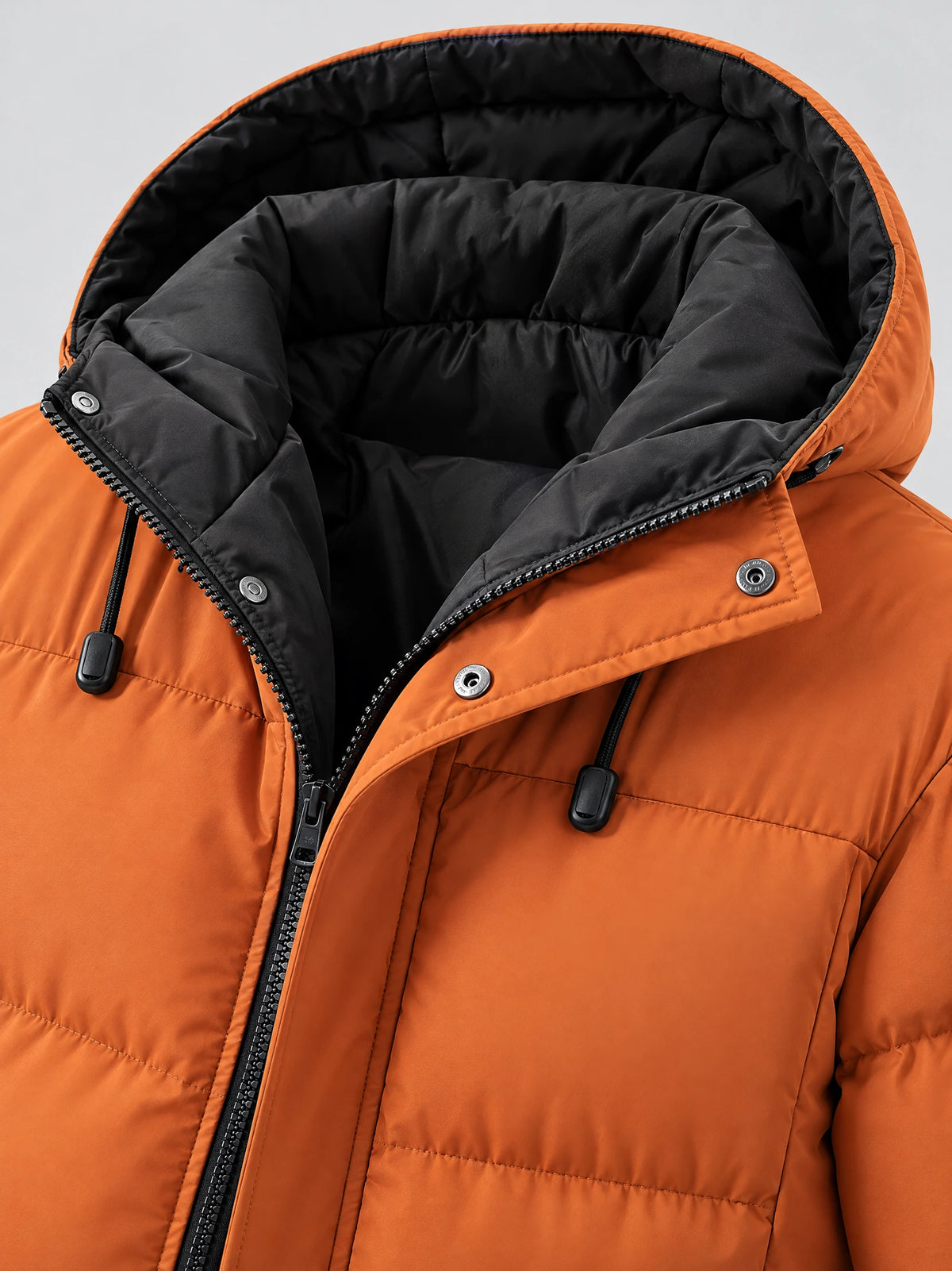 Close-up of an Orange hooded winter jacket with padded hood lining, front zipper, snap-button storm flap, and drawcords.