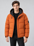 Front studio view of a model wearing an Orange hooded winter jacket with quilted padding, zip front, and drawstring hood.