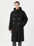 Front studio view of a model wearing a Black wool hooded trench coat with toggle fastenings and patch pockets.