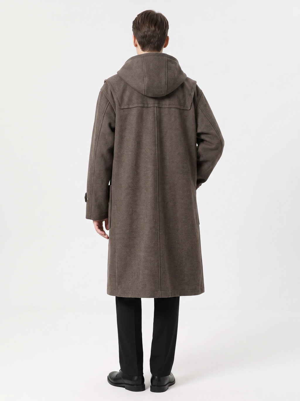 Rear studio view of a model wearing a Brown wool trench coat with a hood, back yoke, and center back seam.