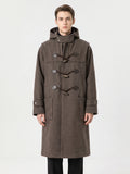 Front studio view of a model wearing a Brown wool trench coat with a hood, toggle fastenings, cuff tabs, and flap pockets.