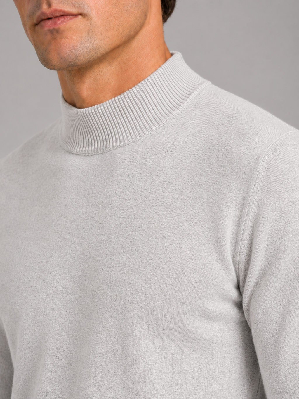 Close up of light gray mock neck sweater showing soft knit texture and refined collar detail