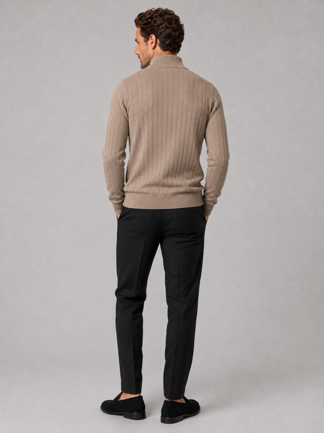 Back view of a man wearing a dark gray quarter zip sweater showing the long sleeves, clean knit construction, and comfortable fit