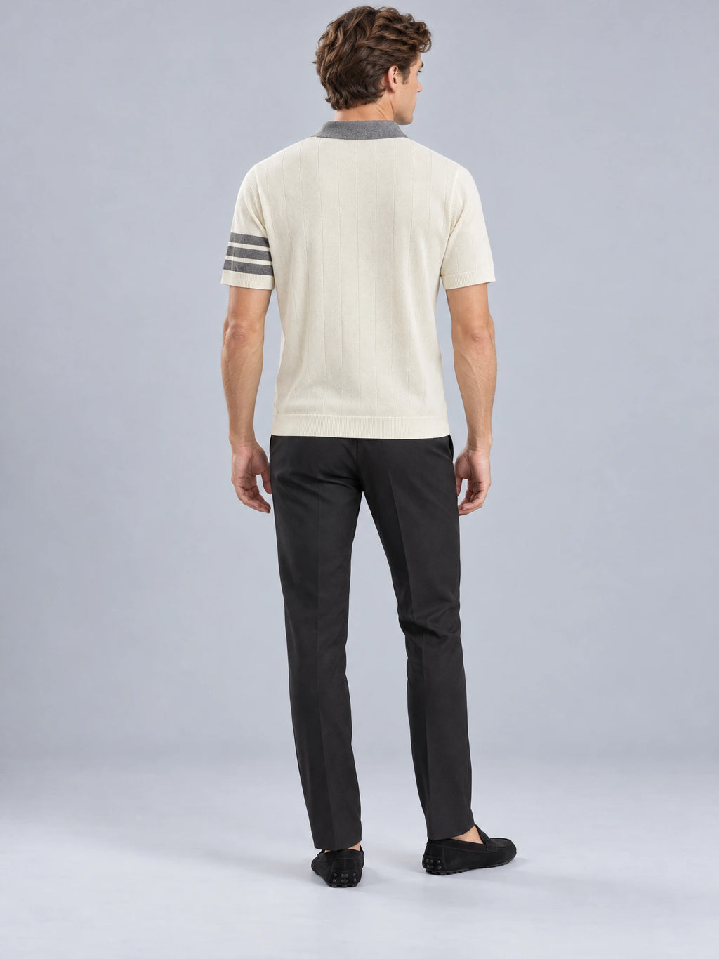 Rear studio view of a model wearing a Beige Knit Polo with a ribbed hem, vertical knit texture, and striped short sleeves.
