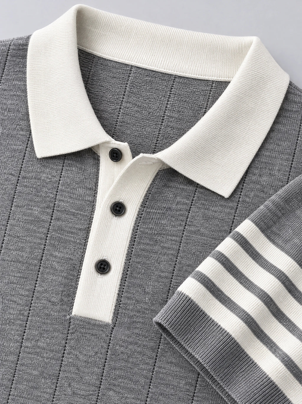 Gray Knit Polo detail showing textured vertical knit, ribbed collar, three-button placket, and striped cuff.