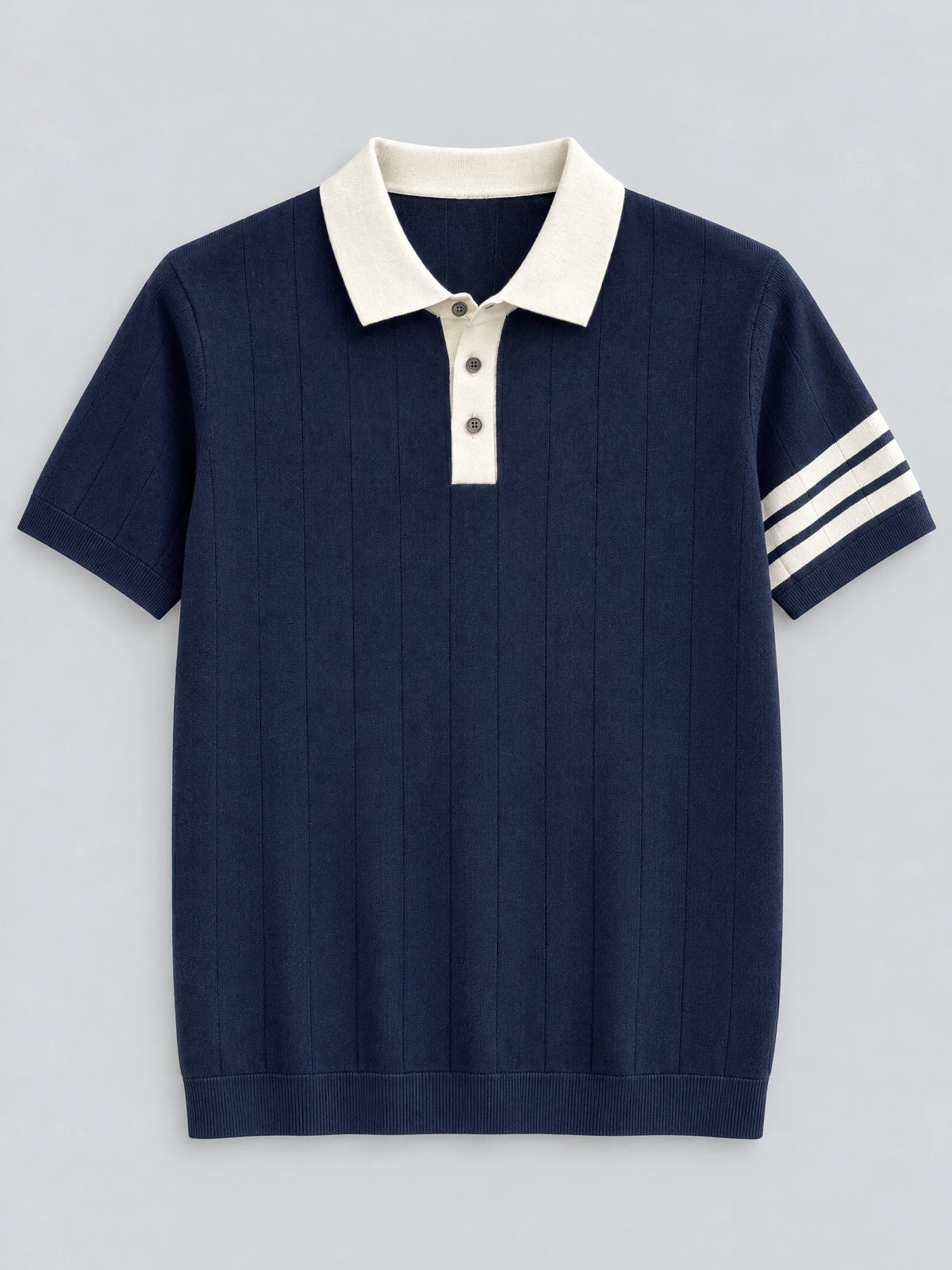 Navy Knit Polo laid flat, featuring a contrast collar, three-button placket, ribbed hem, and striped short-sleeve cuff.