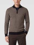 Model wearing a Brown knit quarter zip sweater with a textured knit pattern and ribbed mock neck in a front studio view.