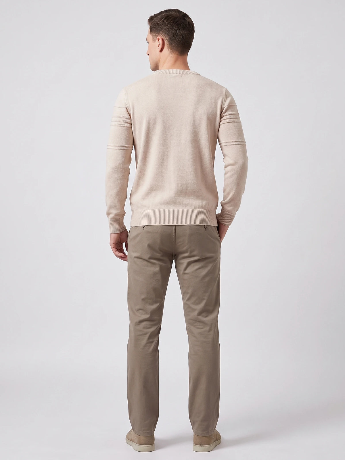 Rear studio view of a model wearing a Beige knitted cotton crewneck sweater with ribbed trim and textured sleeve bands.