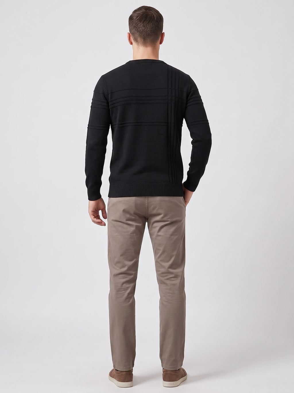Rear studio view of a model wearing a Black knitted cotton crewneck sweater with textured horizontal and vertical back detailing.