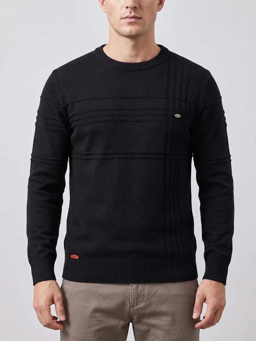 Front studio view of a model wearing a Black knitted cotton crewneck sweater with textured panel stitching and ribbed trim.