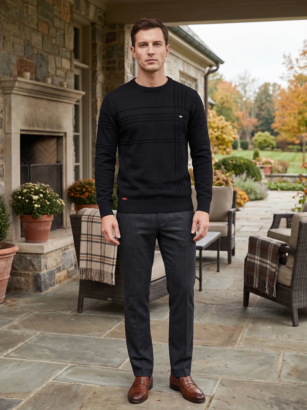 Model wearing a Black knitted cotton crewneck sweater with textured panel detailing on a stone patio.