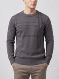 Front studio view of a model wearing a Charcoal knitted cotton crewneck sweater with ribbed trim and textured panel detailing.