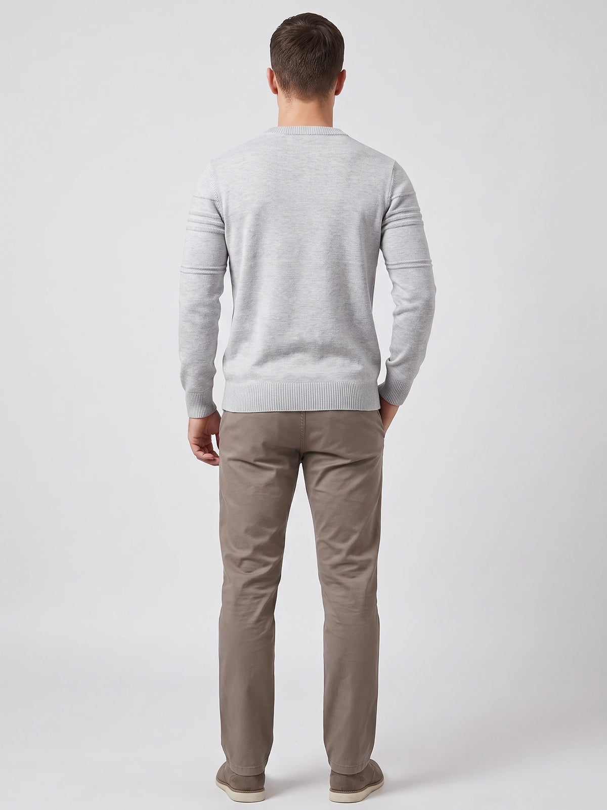 Rear studio view of a model wearing a Gray knitted cotton crewneck sweater with ribbed trim and textured sleeve bands.