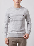 Front studio view of a model wearing a Gray knitted cotton crewneck sweater with textured horizontal and vertical knit stripes.