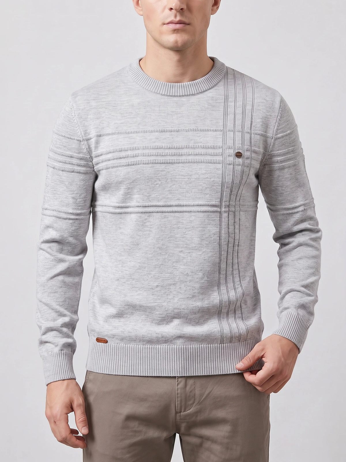 Front studio view of a model wearing a Gray knitted cotton crewneck sweater with textured horizontal and vertical knit stripes.