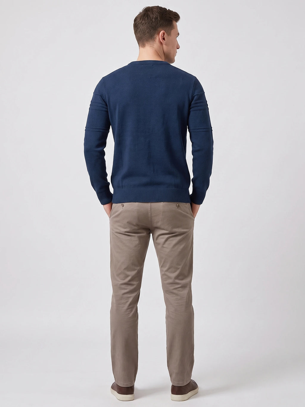 Rear studio view of a model wearing a Navy knitted cotton crewneck sweater with textured sleeve bands and ribbed trim.