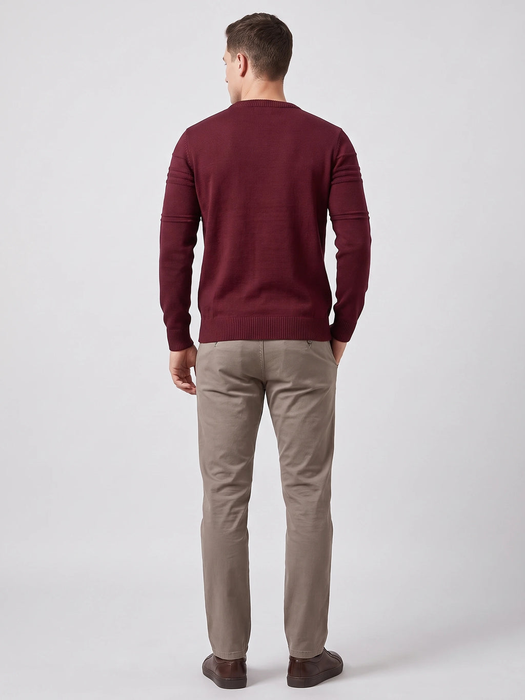 Rear studio view of a model wearing a Wine knitted cotton crewneck sweater with ribbed trim and textured sleeve bands.