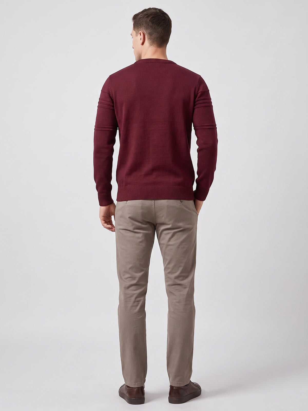 Rear studio view of a model wearing a Wine knitted cotton crewneck sweater with ribbed trim and textured sleeve bands.