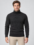 Front studio view of a model wearing a Black knitted turtleneck sweater with textured diagonal knit and ribbed trim.