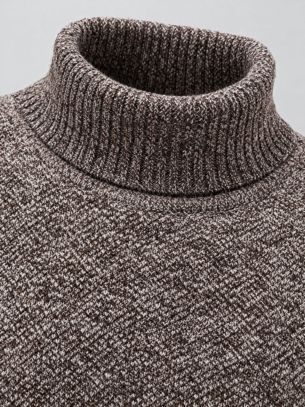Close-up of the ribbed turtleneck collar and textured knit on a Brown wool men's sweater.