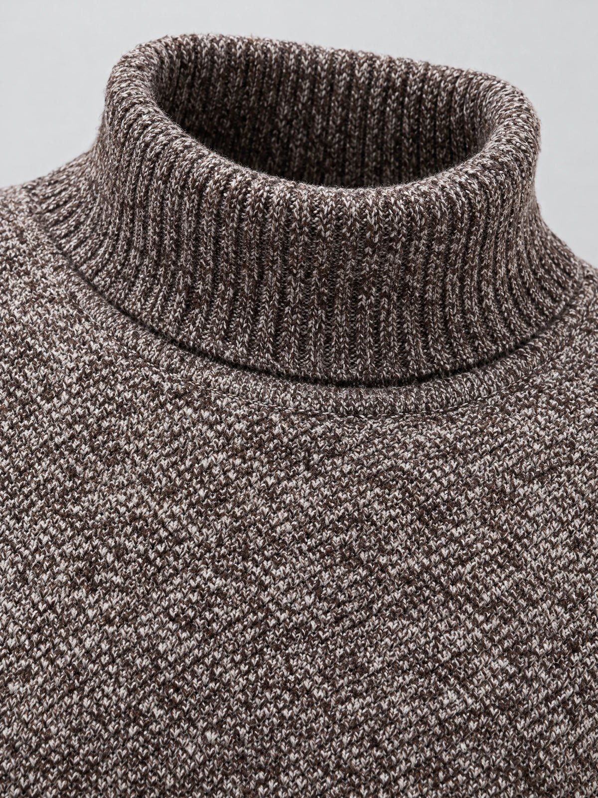 Close-up of the ribbed turtleneck collar and textured knit on a Brown wool men's sweater.