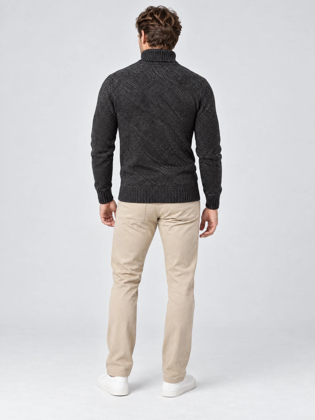 Rear studio view of a model wearing a Gray knitted turtleneck sweater with ribbed collar, cuffs, and hem.