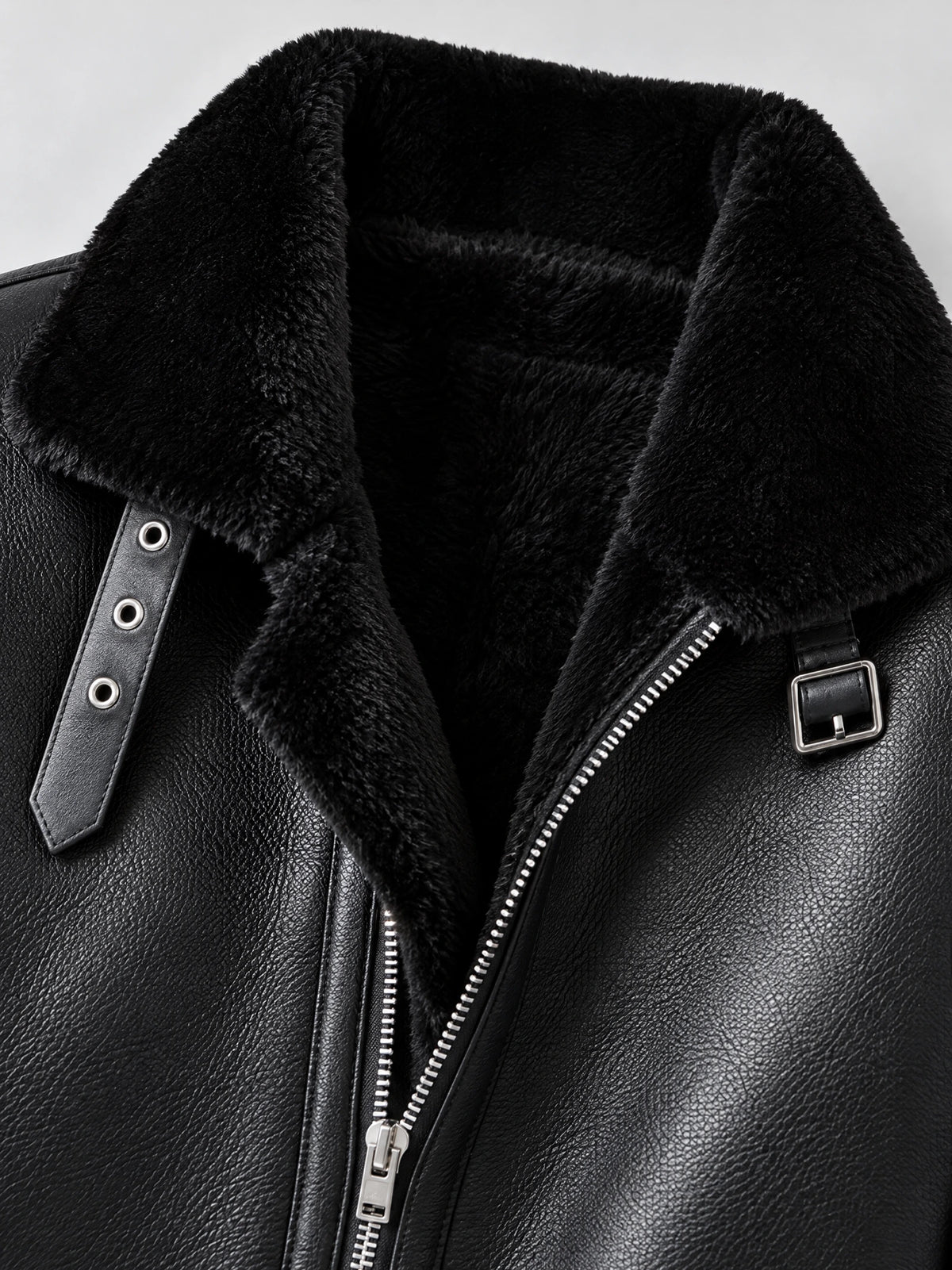 Close-up of the Black Leather Aviator Jacket with plush collar lining, front zipper, snap-tab, and buckle detail.