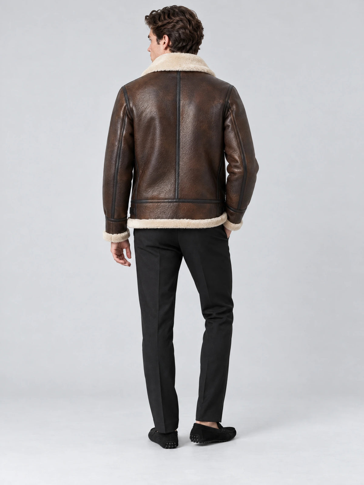 Rear studio view of a model wearing a Brown Leather Aviator Jacket with a shearling-style collar, hem, and cuffs.