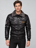 Front studio view of a model wearing a Black Leather Aviator Jacket with a fur collar, zip front, ribbed trim, and chest patches.